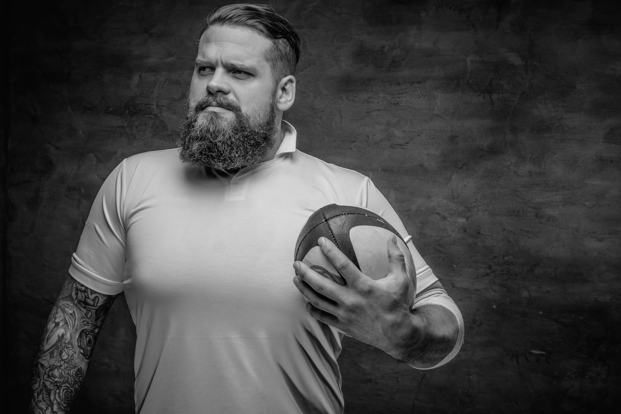Rugbyman tenant le ballon et observant le jeu